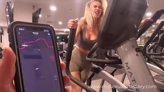 Sexy girl working out with remote control sex toy in public gym